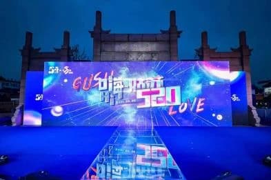 Gusu 520 event stage with a blue and pink backdrop in front of a traditional gateway